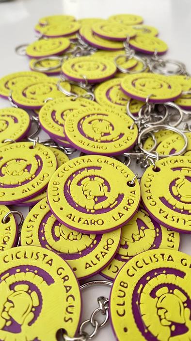 Llaveros amarillos y morados con el escudo del Club Ciclista Gracus