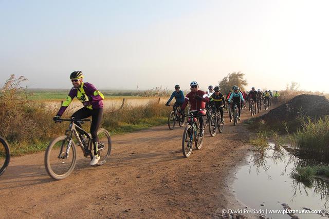 Ciclistas de la quedada 2024 por un camino junto al río